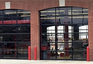 Commercial full view glass garage doors on an oil change facility who rely on a garage door maintenance program from AV Overhead
