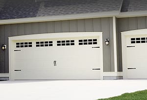 New residential stamped carriage garage doors with stockton windows and decorative hardware