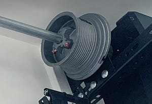 Close view of residential garage door cable, drum,, track and spring