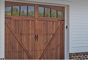 New single and double wood carriage garage doors on home a wooded lot