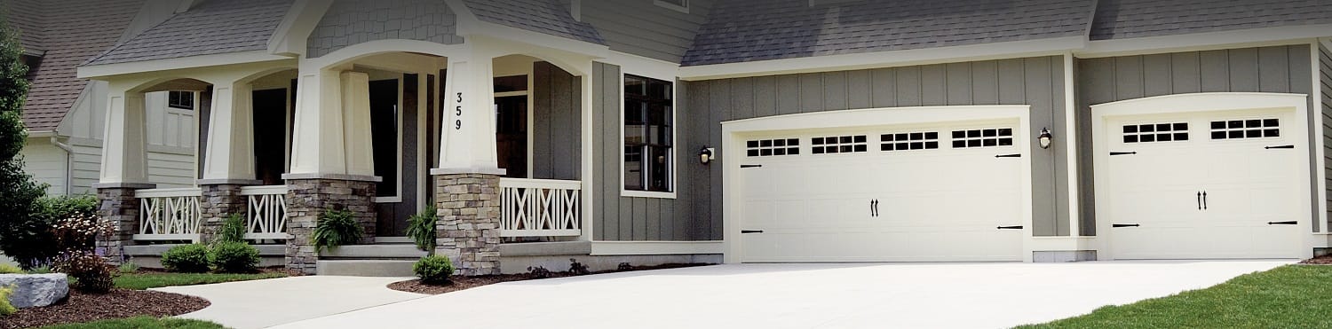 New residential stamped carriage garage doors with stockton windows and decorative hardware
