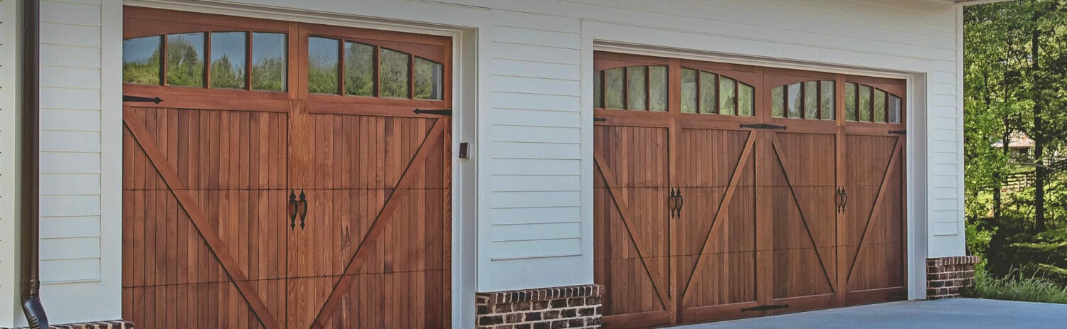 New single and double wood carriage garage doors on home a wooded lot