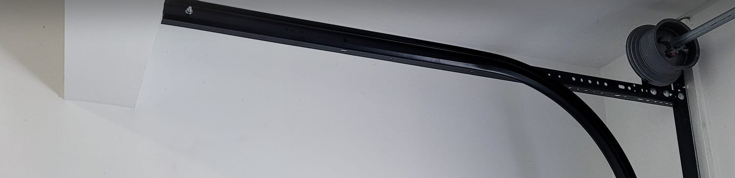 Residential garage door track with cable drum in need of repair service