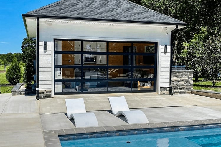 The full view garage door makes a great pool house design, call AV Overhead for exceptional garage door service and designs