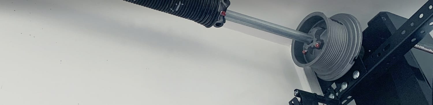 Close view of residential garage door cable, drum,, track and spring
