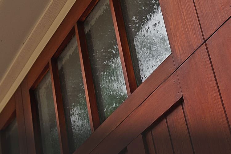 Close up of a new wood carriage garage door with seeded windows