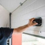 Man manually opening his garage door after his opener is not working